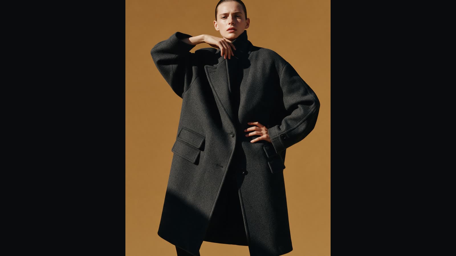 A tall fashion photo in the middle of a wide frame, empty dark sides
